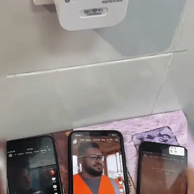 Tres celulares reproduciendo videos a la vez bajo el repetidor