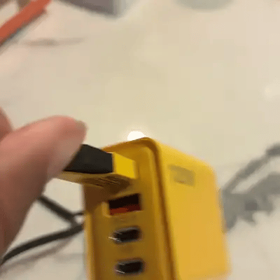 El cable trenzado entrando al cargador amarillo