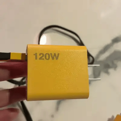 Mano conectando el cable trenzado a uno de los 4 puertos del cargador amarillo