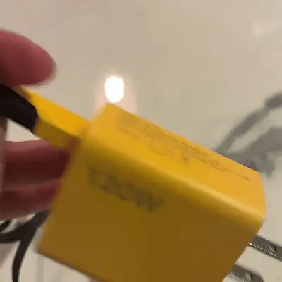 Cargador amarillo de 120 W girando para mostrar su clavija